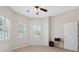 This bedroom features a ceiling fan, neutral walls and a pair of shuttered windows at 11220 Godwit Ct, New Port Richey, FL 34654
