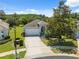 Exterior view of a well-maintained home with a two-car garage and mature landscaping at 11220 Godwit Ct, New Port Richey, FL 34654