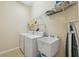 This well-equipped laundry room includes washer, dryer, utility sink and shelving at 11220 Godwit Ct, New Port Richey, FL 34654