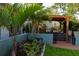 Backyard featuring a pergola, outdoor seating area, and lush tropical landscaping at 12021 144Th St, Largo, FL 33774