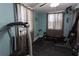 Well-equipped exercise room featuring workout machines and soft natural light from curtained windows, perfect for a home gym at 12021 144Th St, Largo, FL 33774