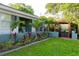 Charming home with a vibrant front yard, lush landscaping, and an inviting pergola for relaxing outdoors at 12021 144Th St, Largo, FL 33774