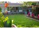 Well-manicured front yard with colorful flowerbeds, lush green lawn, and a charming home exterior at 12021 144Th St, Largo, FL 33774