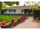 Charming home with a well-manicured lawn, vibrant landscaping, and a welcoming pathway at 12021 144Th St, Largo, FL 33774