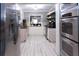 Bright kitchen with stainless steel appliances, light cabinets, a pass through, and light wood-look tile floors at 12021 144Th St, Largo, FL 33774