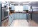 Well-equipped kitchen with light blue cabinets, stainless steel appliances, and granite countertops at 12021 144Th St, Largo, FL 33774