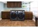 Modern laundry room with front loading washer/dryer and custom cabinets at 12021 144Th St, Largo, FL 33774