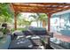 Outdoor patio seating under a wooden pergola with modern furniture, creating a perfect relaxation space at 12021 144Th St, Largo, FL 33774