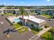 Aerial view of condo building, palm trees, and community pool with surrounding parking lot at 1250 S Pinellas Ave # 405, Tarpon Springs, FL 34689