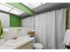 Well-lit bathroom featuring a vanity, toilet, bathtub with shower curtain, and decorative mirror at 1250 S Pinellas Ave # 405, Tarpon Springs, FL 34689