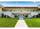 Low-rise condominium features a staircase to the second level and manicured landscaping at 1250 S Pinellas Ave # 405, Tarpon Springs, FL 34689