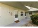 Condominium entrance featuring a front door with security peephole, exterior lighting and landscaping at 1250 S Pinellas Ave # 405, Tarpon Springs, FL 34689