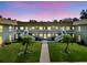 Charming condo building with white railings, palm trees, and a vibrant green lawn at dusk at 1250 S Pinellas Ave # 405, Tarpon Springs, FL 34689