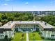 View of a two-story condo building with stairs leading to the upper units and a landscaped courtyard at 1250 S Pinellas Ave # 405, Tarpon Springs, FL 34689