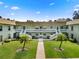 Exterior of a two-story condo building with a well-manicured front courtyard and lush landscaping at 1250 S Pinellas Ave # 405, Tarpon Springs, FL 34689