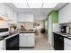 Bright kitchen featuring white cabinets, black appliances, and checkered countertops for a modern touch at 1250 S Pinellas Ave # 405, Tarpon Springs, FL 34689