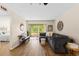 Bright and airy living room with wood-look flooring, neutral paint, and large sliding glass doors to a balcony at 1250 S Pinellas Ave # 405, Tarpon Springs, FL 34689