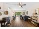Inviting living room featuring wood-look flooring, ceiling fan, neutral paint and balcony access with views of a garden at 1250 S Pinellas Ave # 405, Tarpon Springs, FL 34689
