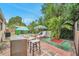 Backyard with brick patio, mature tropical landscaping, lounge chairs and unique shed/cabana at 12790 118Th St, Seminole, FL 33778