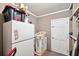 Garage interior featuring a white refrigerator, black storage containers, laundry basket, and a white door at 12790 118Th St, Seminole, FL 33778