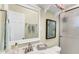 Bathroom with a vanity, white sink, framed mirror, decorative shelf, and glass door shower at 1403 Garden Ave, Tarpon Springs, FL 34689