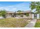 Charming single-story home featuring a stone accent wall and manicured landscaping at 1403 Garden Ave, Tarpon Springs, FL 34689