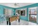 Vibrant game room featuring a foosball table, bright turquoise walls, and access to the pool area at 1403 Garden Ave, Tarpon Springs, FL 34689