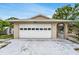 Spacious two-car garage with an attached covered patio and manicured landscaping at 1403 Garden Ave, Tarpon Springs, FL 34689