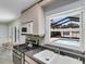 Bright kitchen featuring granite countertops, a stainless steel stove, and a window view of the screened-in pool at 1403 Garden Ave, Tarpon Springs, FL 34689
