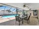Covered patio with outdoor dining set, ceiling fans, and views of the pool area at 1403 Garden Ave, Tarpon Springs, FL 34689