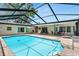 Screened-in pool with blue tiles and outdoor seating offers a private backyard escape at 1403 Garden Ave, Tarpon Springs, FL 34689