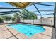 Screened-in pool area featuring a covered patio and brick surround, great for relaxing outdoors at 1403 Garden Ave, Tarpon Springs, FL 34689