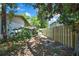 Backyard features a wooden fence, lush greenery, and mature trees, creating a private outdoor space at 14615 Daybreak Dr, Lutz, FL 33559