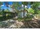 Exterior view of home with screened-in porch and lush, mature landscaping in backyard at 14615 Daybreak Dr, Lutz, FL 33559