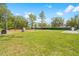 Spacious backyard with lush green grass, trees and partial fence, great for outdoor activities at 15062 Hummingbird Rd, Weeki Wachee, FL 34614
