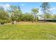 Spacious backyard with lush green grass, trees and partial fence, great for outdoor activities at 15062 Hummingbird Rd, Weeki Wachee, FL 34614