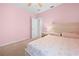 Bright bedroom with a bed, nightstand, and pink walls at 15062 Hummingbird Rd, Weeki Wachee, FL 34614
