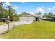 Charming single-story home featuring a 3-car garage, manicured lawn, and mailbox with house number at 15062 Hummingbird Rd, Weeki Wachee, FL 34614