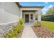 Inviting front entrance featuring a stone-accented porch, decorative plants, and manicured mulch beds at 15062 Hummingbird Rd, Weeki Wachee, FL 34614