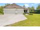 Exterior of house with a 3-car garage showcasing a spacious driveway and manicured front yard at 15062 Hummingbird Rd, Weeki Wachee, FL 34614