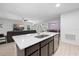 Kitchen island features white countertops, stainless faucet, and views into the dining and living rooms at 15062 Hummingbird Rd, Weeki Wachee, FL 34614