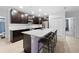 Modern kitchen features an island with bar stool seating, stainless steel appliances, and dark cabinets at 15062 Hummingbird Rd, Weeki Wachee, FL 34614