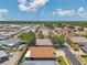 Wide aerial view capturing a neighborhood with neatly arranged homes, streets, and a backdrop of mature trees at 1747 Wood Brook St, Tarpon Springs, FL 34689