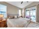 Spacious bedroom featuring a large bed, neutral color palette, and sliding glass doors to a screened patio at 1747 Wood Brook St, Tarpon Springs, FL 34689
