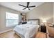 Cozy bedroom features a ceiling fan, window with blinds, a comfortable bed with decorative pillows, and storage shelves at 1747 Wood Brook St, Tarpon Springs, FL 34689