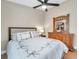 Bedroom showcases a comfortable bed with decorative pillows, a ceiling fan, and a wooden dresser with a decorative mirror at 1747 Wood Brook St, Tarpon Springs, FL 34689