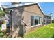 Side view of a home showing the textured exterior, a window, and a glimpse of the screened-in porch at 1747 Wood Brook St, Tarpon Springs, FL 34689