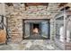 Close-up of a stone fireplace with a protective screen and stone floors at 1747 Wood Brook St, Tarpon Springs, FL 34689