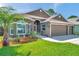 Landscaped front yard of home with lush green grass, a palm tree, and a 'welcome' sign at 1747 Wood Brook St, Tarpon Springs, FL 34689
