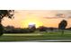 Scenic golf course view at sunset with manicured greens and distant buildings at 1747 Wood Brook St, Tarpon Springs, FL 34689